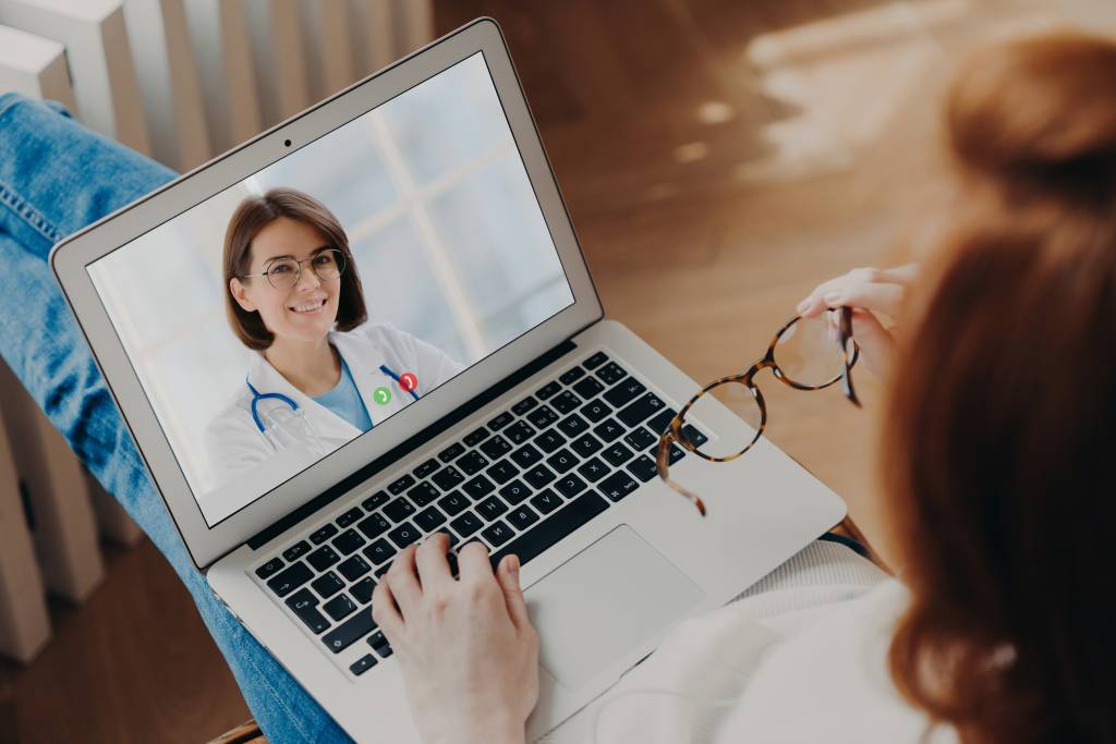 Woman has video chat with experienced doctor on laptop computer gets consultancy.